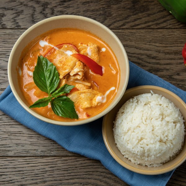 Bai Tong Thai red curry with chicken, bell peppers, and basil, served with white rice.