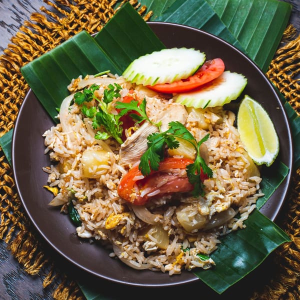 Bai Tong Thai fried rice with chicken, egg, onions, tomatoes, cucumbers, cilantro, and lime.